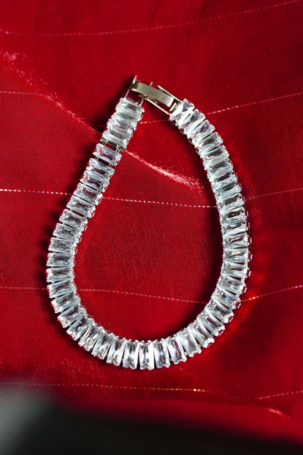 Silver bracelet on a red fabric background