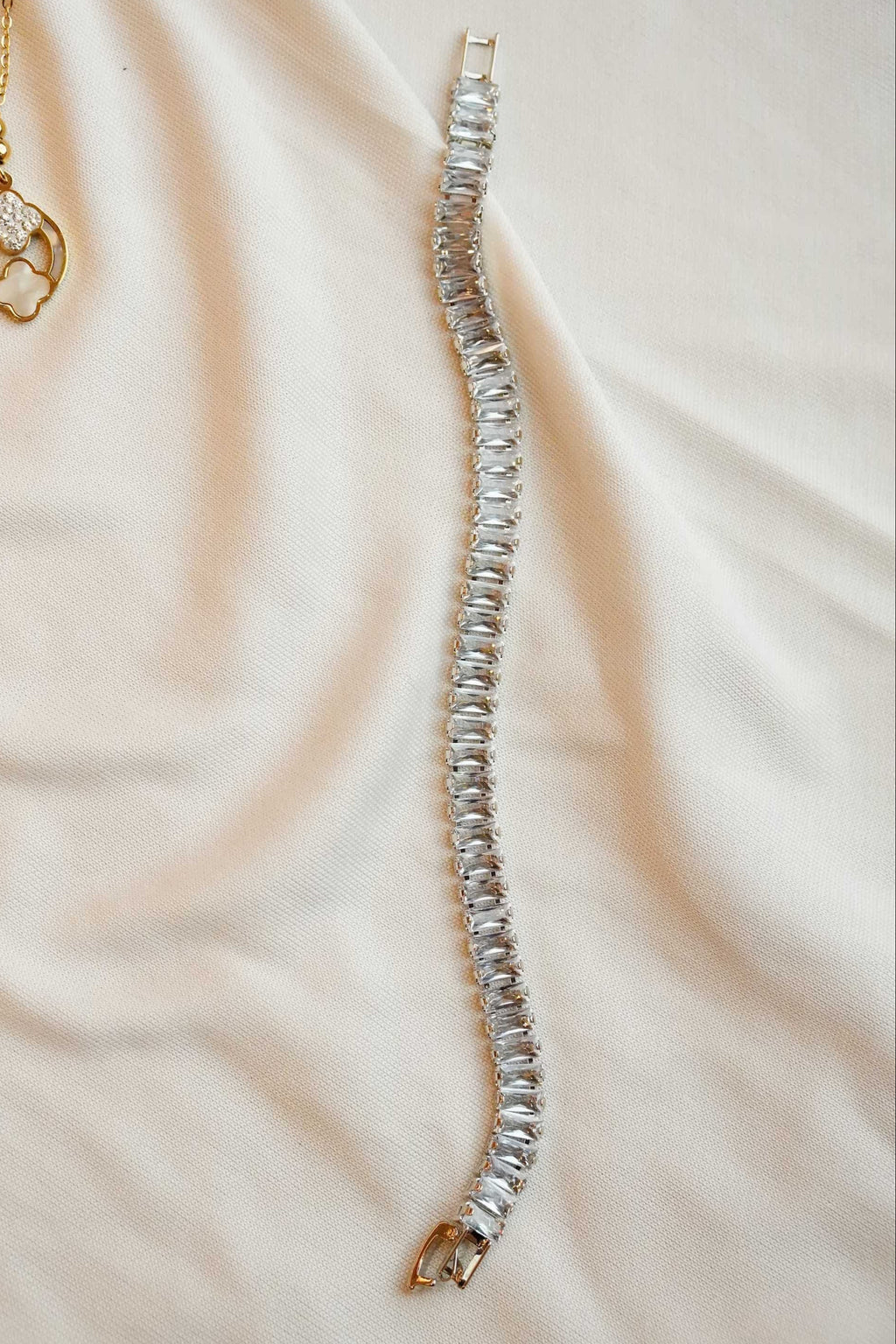 Silver bracelet on a beige fabric background