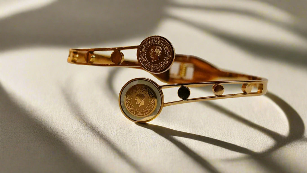 Gold ss bracelet with circular designs on a textured beige surface