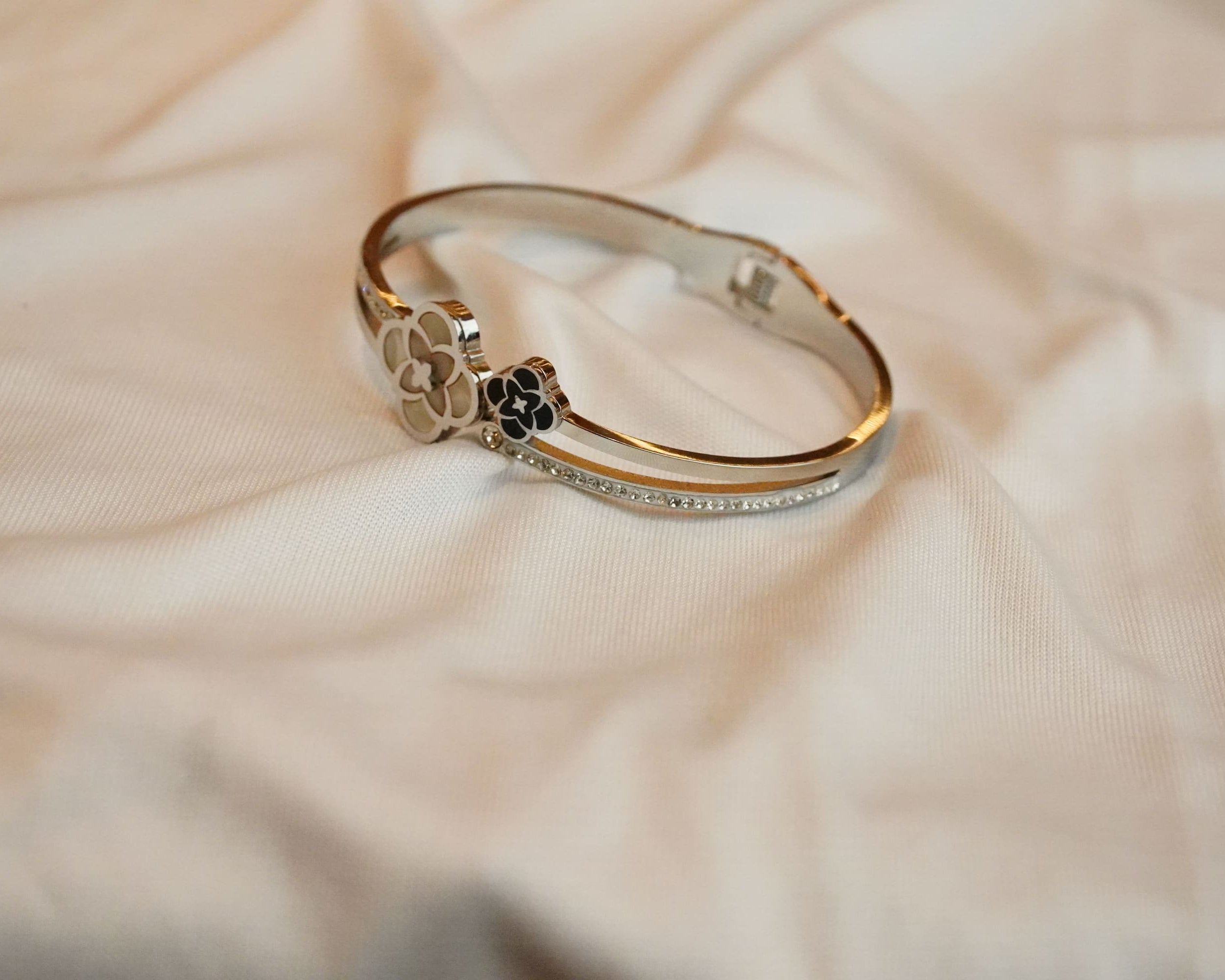 Gold and silver ss bracelet on a beige fabric background
